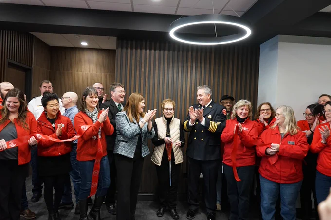 DOA Secretary Kathy Blumenfeld joins Town of Beloit Administrator Tim Wellnitz, Fire Chief Daniel Pease, and stakeholders in red jackets applaud after a ceremonial ribbon cutting for the new Town Hall and Fire Station.