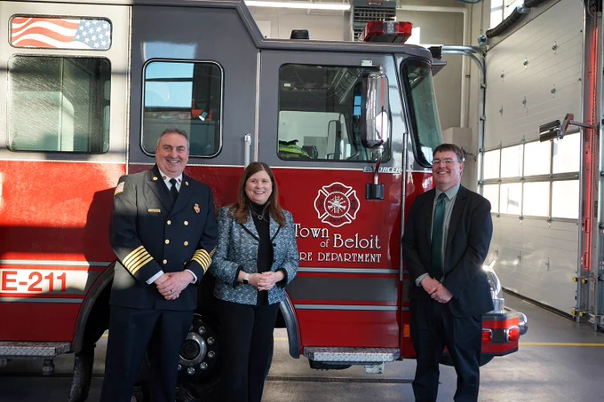 DOA Secretary Kathy Blumenfeld, Town of Beloit Administrator Tim Wellnitz, and Fire Chief Daniel Pease stand in front of a fire truck in the new station.