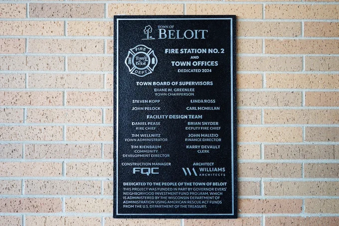A dedication plaque for the Town of Beloit Fire Station No. 2 and Town Hall lists town supervisors, facility design team members, construction manager, and architectural firm.