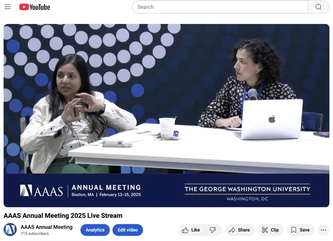Two panelists are engaged in a discussion at the AAAS Annual Meeting 2025, hosted in Boston, MA and presented by The George Washington University. The scene includes a laptop and personal microphones for each speaker, set against a backdrop with circular patterns.