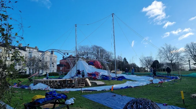 A partially constructed circus style tent.