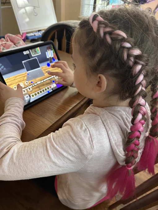 Girl on iPad with Minecraft Education CyberSafe AI: Dig Deeper on screen