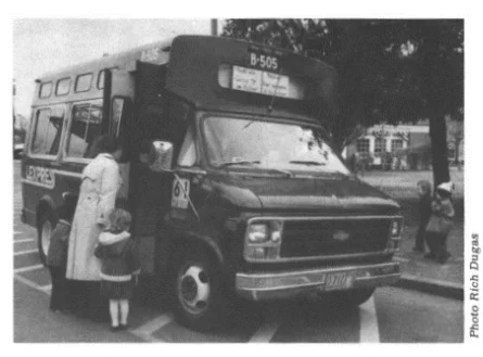 Black and white photo of woman and child getting on to a Lexpress bus