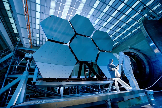 Solar scientist checks solar panels while wearing a clean suit.