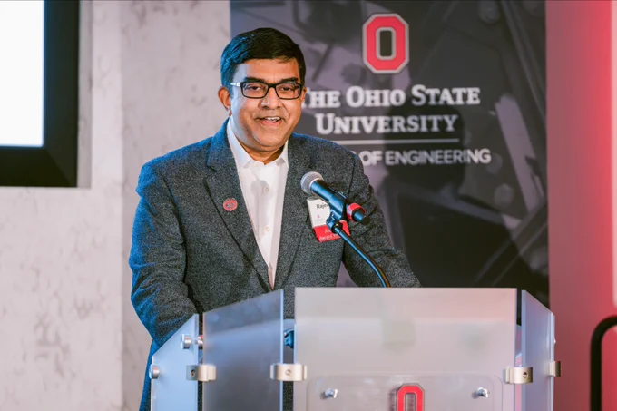 Person standing at a podium with The Ohio State University College of Engineering logos, giving a speech at an event.