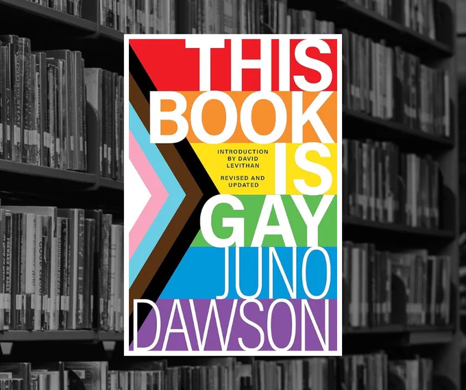 Book cover of "This Book is Gay" by Juno Dawson, over a black and white photo of bookshelves in the library.