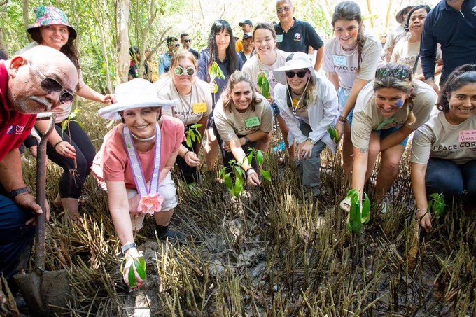 Ambassador MaryKay Carlson planting mangroves with Peace Corps Philippines volunteers.