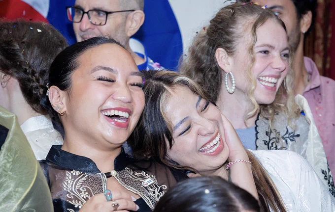 Three Peace Corps volunteers smiling during the swearing in ceremony.