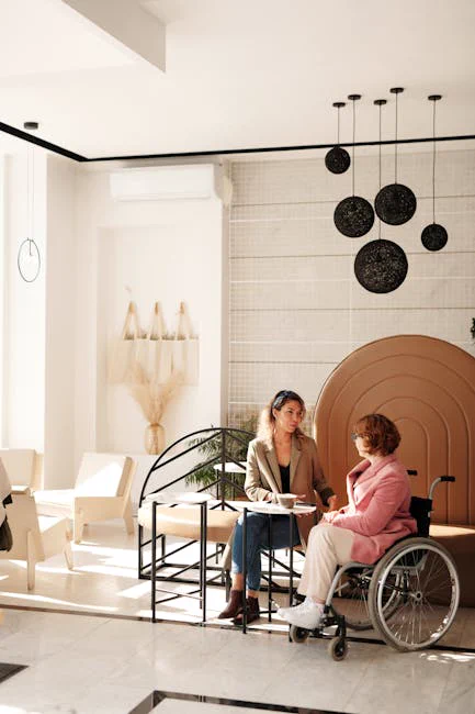 A business meeting between two women, one in a wheelchair, in a stylish modern room.