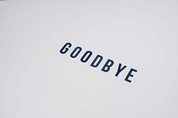Simple typography displaying the word goodbye on a clean white background, offering ample copy space.