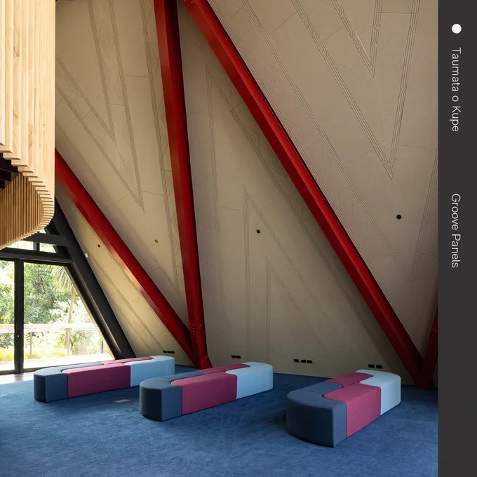 Interior of Tūranga Christchurch Central Library showing colorful modular seating and striking wooden beams with red accents.