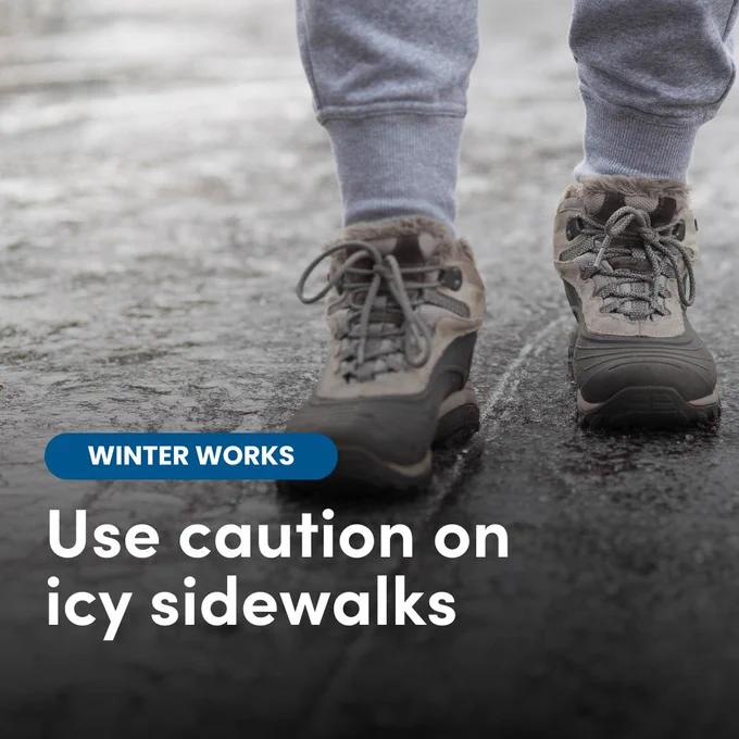 An image of feet walking on an icy sidewalk with text that reads 'Use caution on icy sidewalks'.