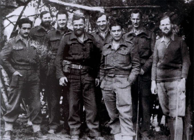 Black and white photo of 8 men in army uniform.