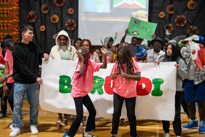 Students carry a flag and dance during a Parade of Nations.