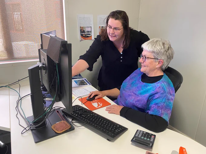 Free Diploma of IT student, Vicki Kane, helps an elderly resident with the computer at her workplace, Country Universities Centre Ovens Murry.
