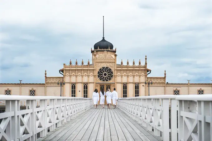 Four people walking towards a cold bathing house