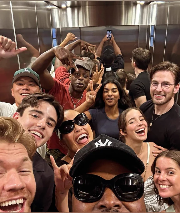 Picture of Samson taking a selfie in an elevator with 10 other people including Chris Evans.