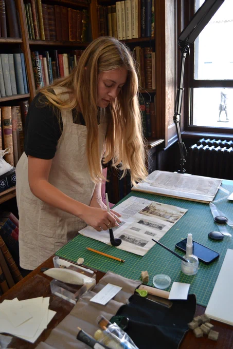 Image showing a conservation student surface-cleaning a page from the Jackson collection at the Society of Antiquaries.  Seven students benefited from paid summer placements on this project.