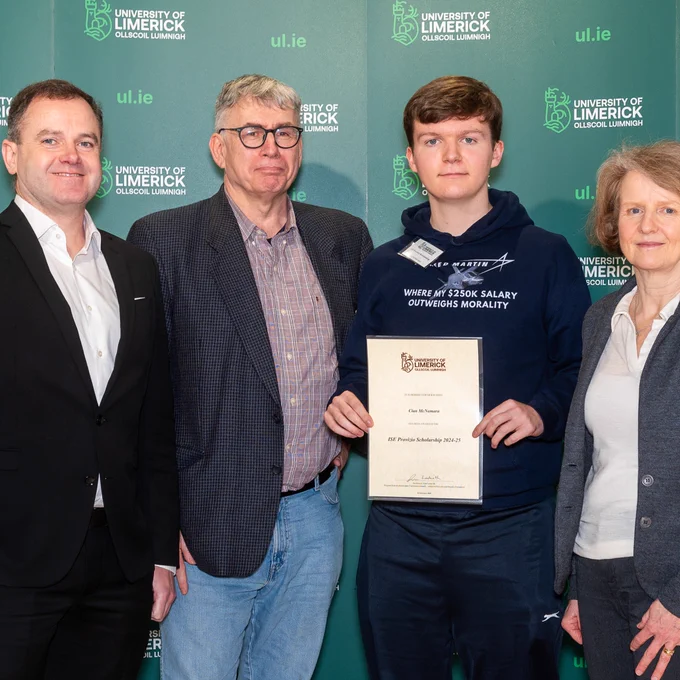 Immersive Software Engineering student Cian McNamara surrounded by University of Limerick staff holding a certificate to represent that he received the Provisio Scholarship 2024-25 at the 2025 UL Scholarship Awards Ceremony. There is a green backdrop with ul.ie and the UL logo as a repeating pattern.