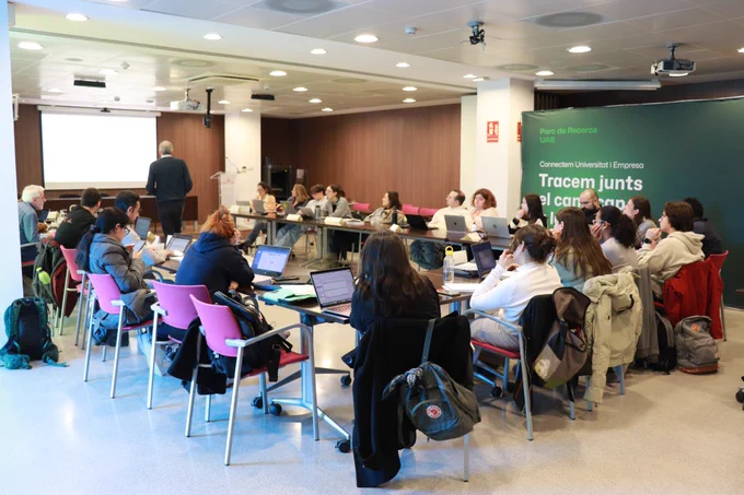 Sessió informativa del Seminaris d'innovació i transferència, amb l'alumnat en una taula en forma d'U amb l'instructor al capdavant. 