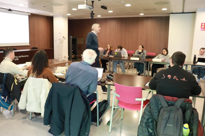 Sessió informativa del Seminaris d'innovació i transferència, amb l'alumnat en una taula en forma d'U amb l'instructor al capdavant. 