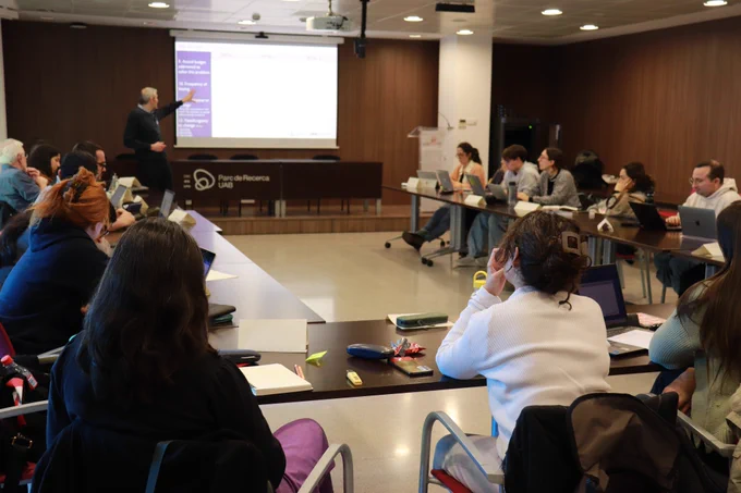 Sessió informativa del Seminaris d'innovació i transferència, amb l'alumnat en una taula en forma d'U amb l'instructor al capdavant. 