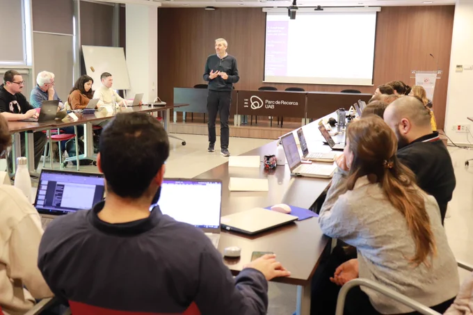 Sessió informativa del Seminaris d'innovació i transferència, amb l'alumnat en una taula en forma d'U amb l'instructor al capdavant. 