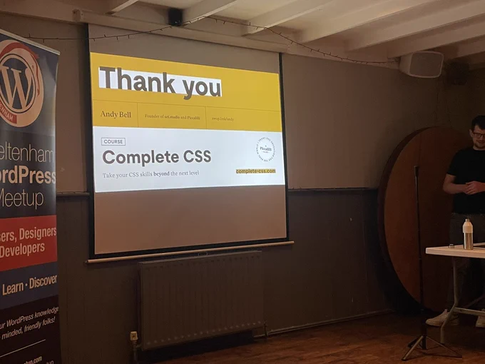 Banner, projector screen showing final slide and presenter