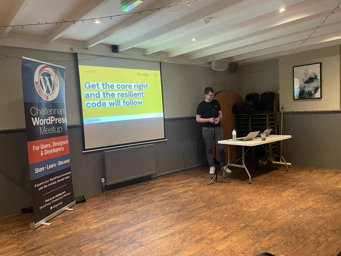 Banner, projector screen showing slide and presenter