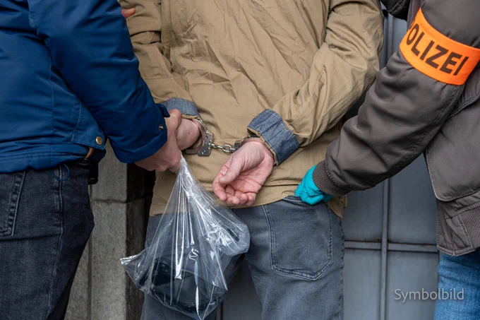 Symbolbild der Kantonspolizei Zürich: eine Person in Handschellen mit einer Plastiktüte hinter ihrem Rücken