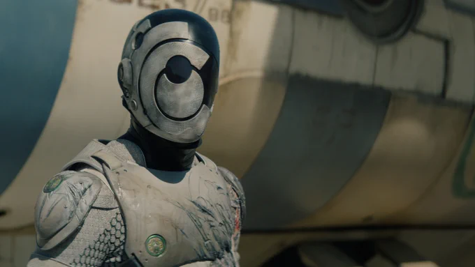 Murderbot (played by Alexander Skarsgård), in its suit with its helmet on, stands outside the ship.