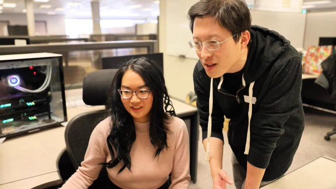 Waterloo researchers Amy Tai (left) and Alexander Wong looking at a screen together