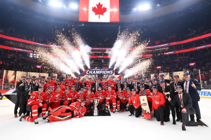 The entire Canadian team posing for a photo on ice after winning the 4 Nations Face-Off