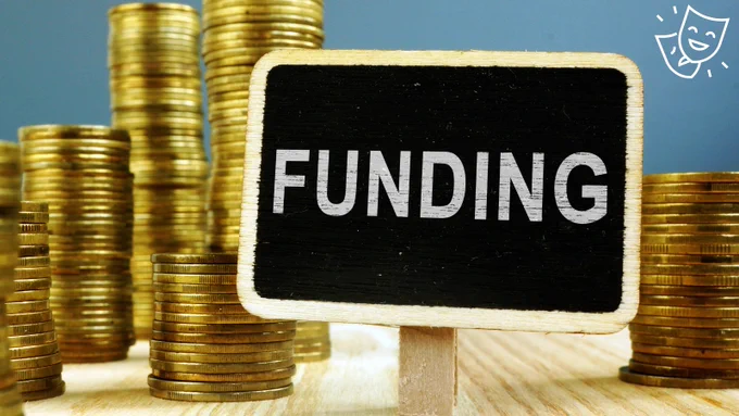 A pile of coins surrounded by a sign with 'funding' written on it.