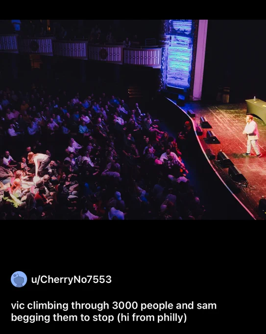 A Reddit-posted photo in which Vic climbs over the heads of the audience at a Dropout Improv show while Sam looks worriedly on from stage.