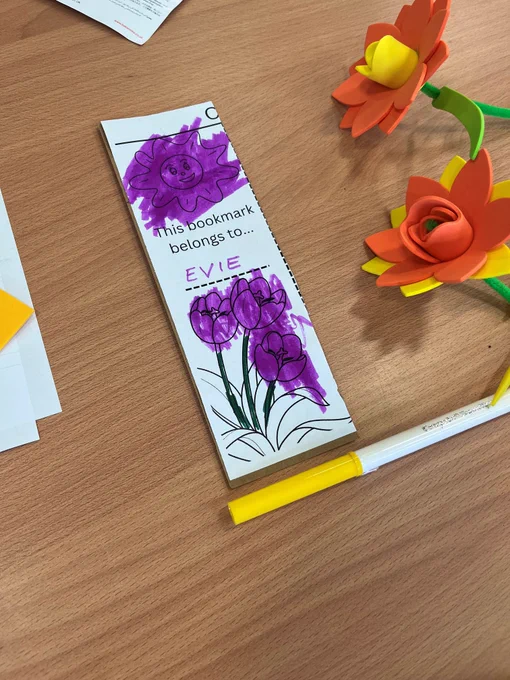 Picture shows a bookmark that has purple coloured flowers and some foam daffodils.