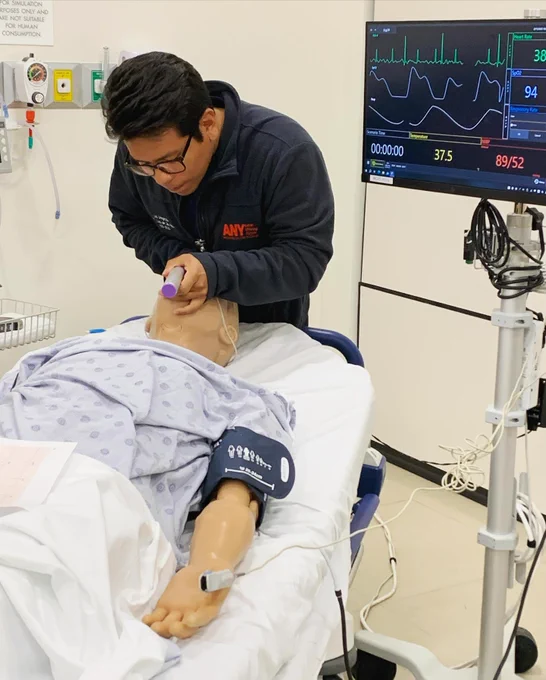 One doctor works on intubating a simulation manikin.