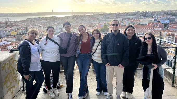Eight Adelphi community members posing for a photo in Portugal