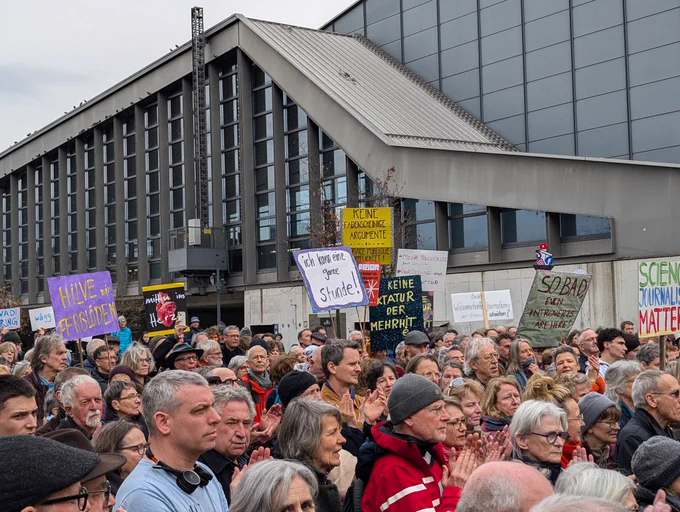 Leuten draussen Bahnhof SBB Basel, mit Schild, im Protest