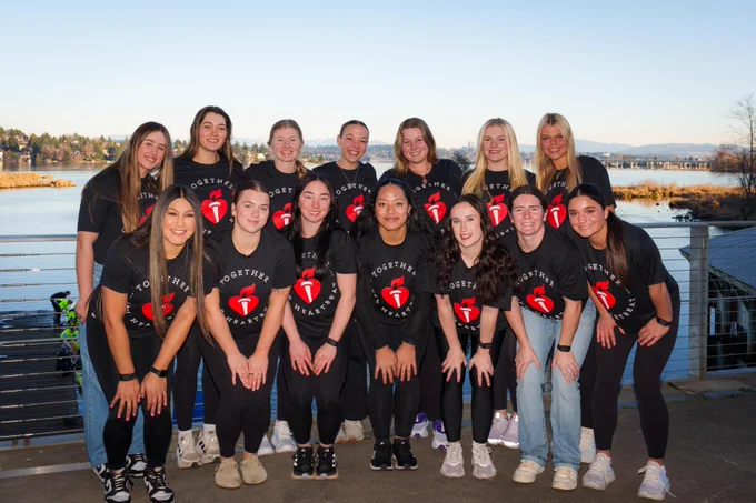 Athletes from UW Softball pose for a group photo wearing American Heart Association t-shirts.