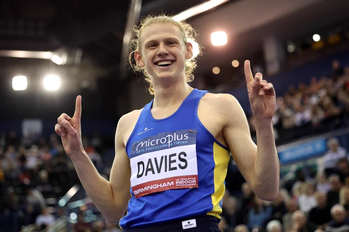 Justin Davies smiling and holding his hands up