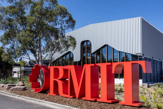 A large red RMIT sign outside the RMIT Trades Innovation Centre. 