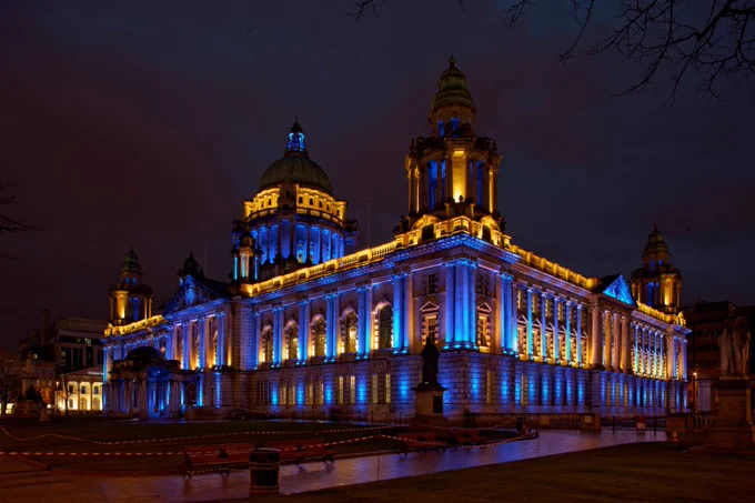 City Hall illuminated in blue and yellow.