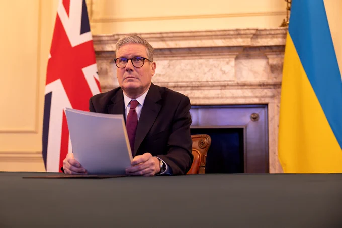 Keir Starmer at the Cabinet room table with the UK and Ukraine flags behind him