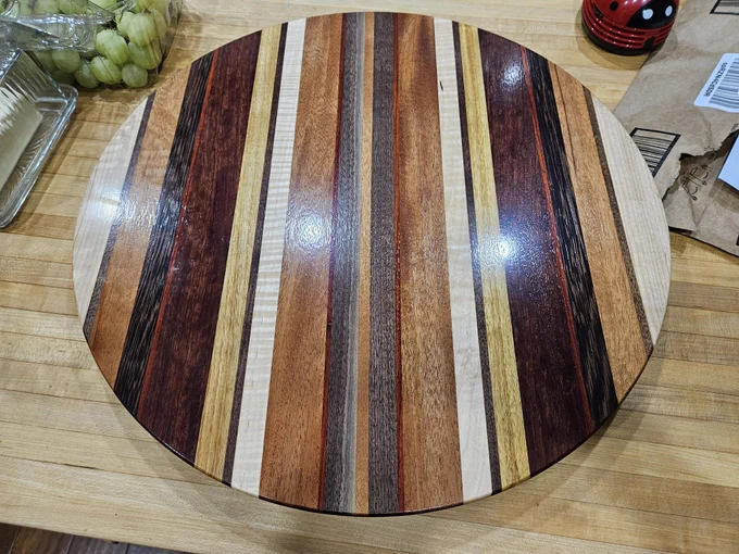 Top down voew of Lazy susan made from varying thick and thin strips of walnut, maple, canary, mahogany, padauk, wenge and curly soft maple.