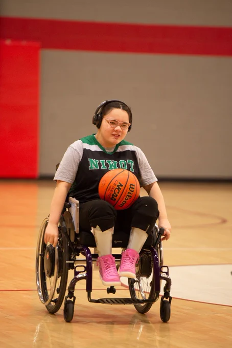 Niwot High unified player moves the ball up the court on her wheelchair