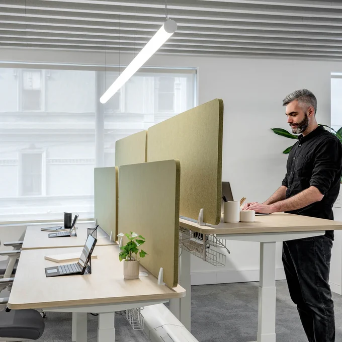 Person working at a standing desk in a modern, well-lit office setting.