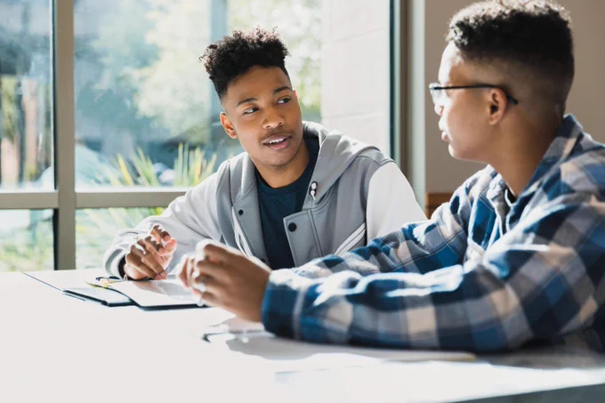 Student talking to his classmate at university.