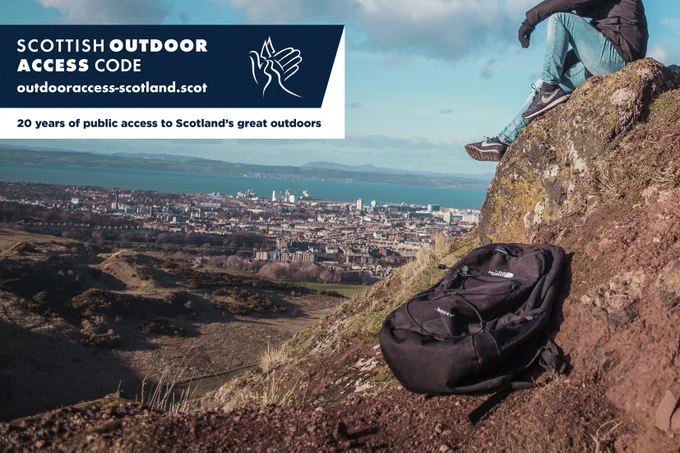 Photo of a man sitting on a hillside with a rucksack on the ground next to him. Text on image: 20 years of public access to Scotland's great outdoors. Image credit: Jonathan Francisca on Unsplash.