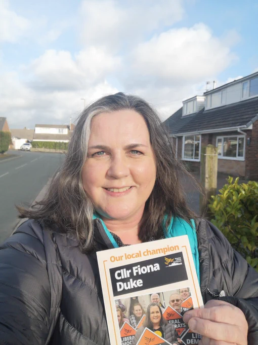 Cllr Fiona Duke smiling with a leaflet 